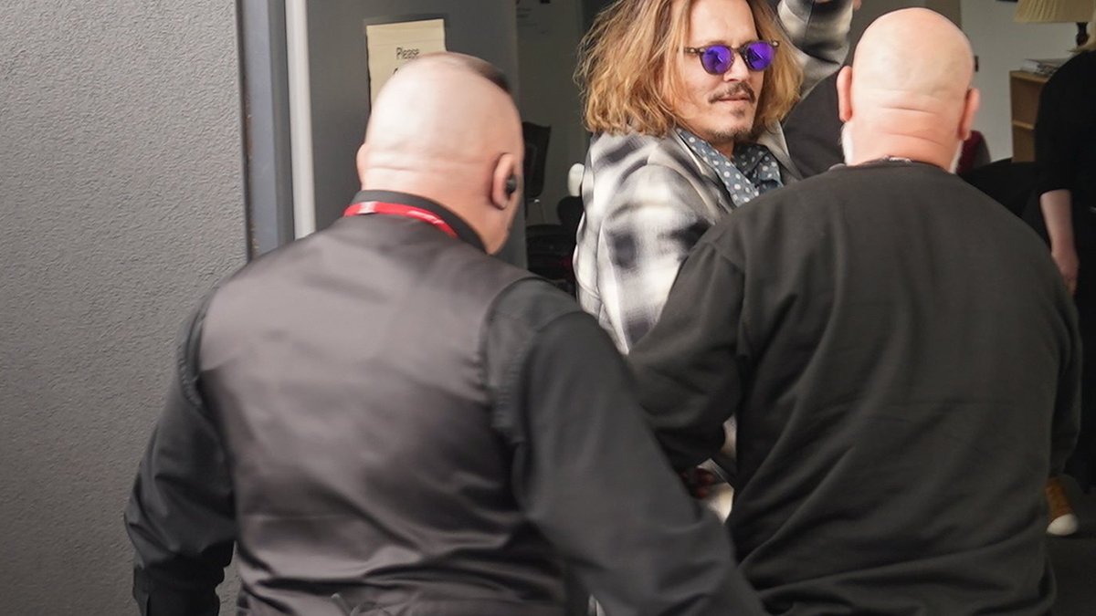 Johnny Depp ‘scortato’ fuori dall’hotel con una tazza di caffè in mano (foto)